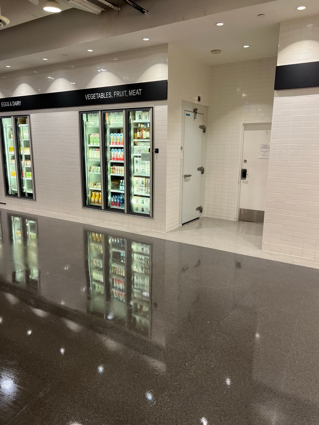 Finished concrete floor at Dalina, reflecting the fridges like a mirror